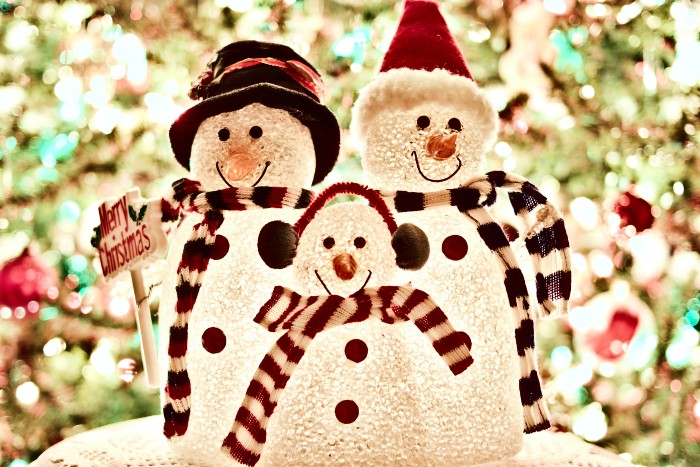 Três bonecos de neve com cachecol colorido